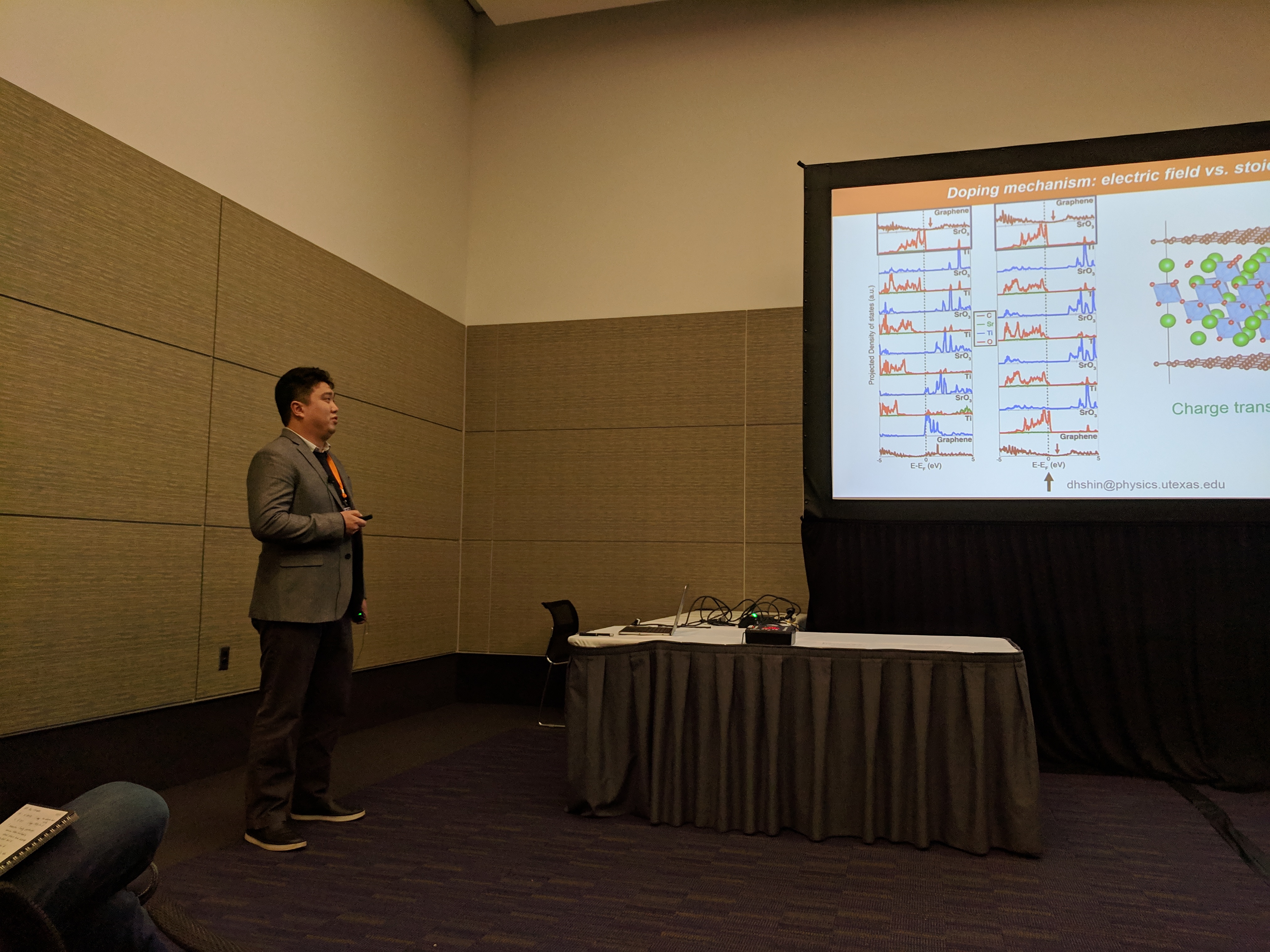 Donghan next to a projection screen with one of the slides from his talk.